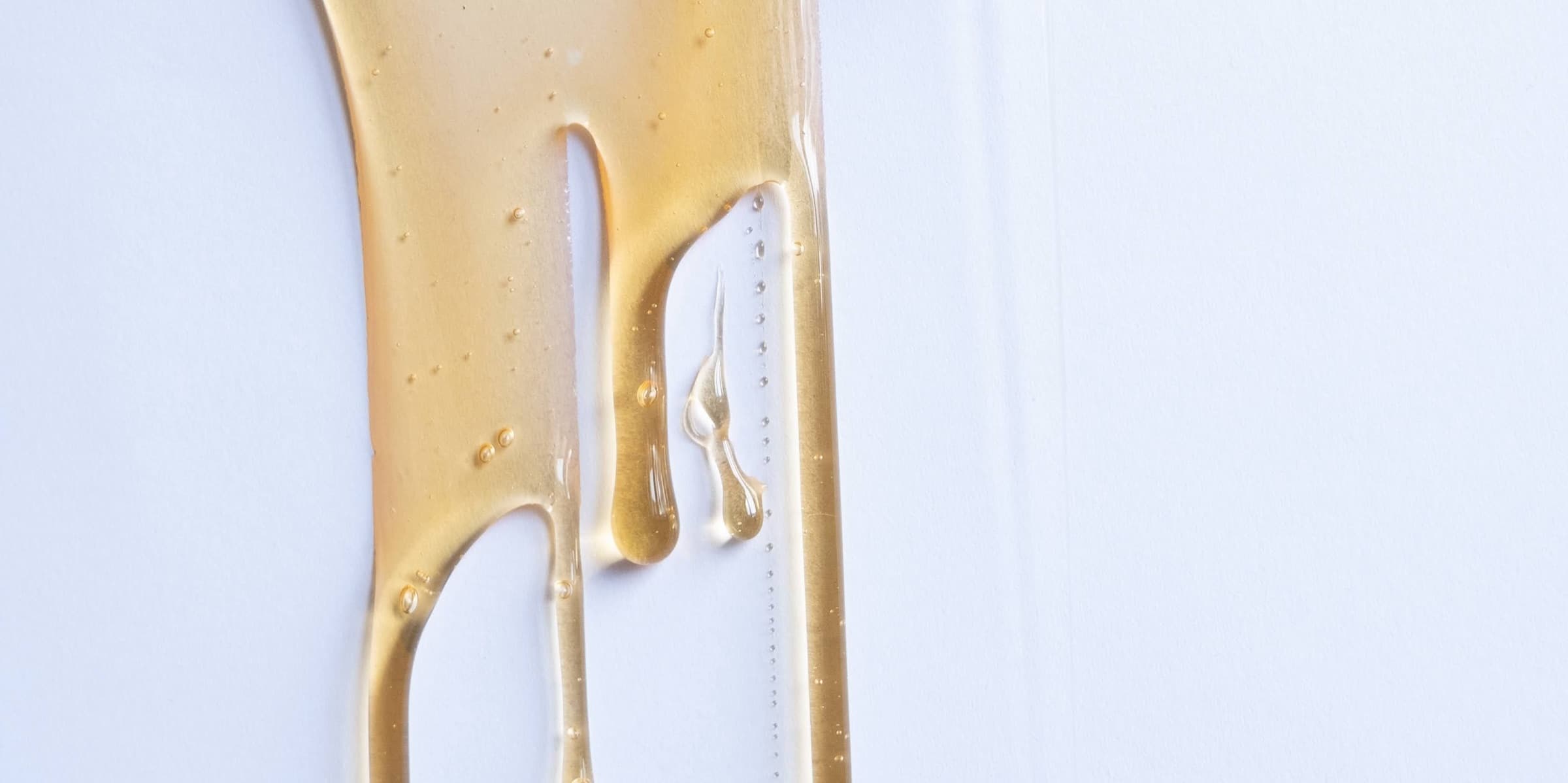 Thick honey flowing slowly from a dipper
