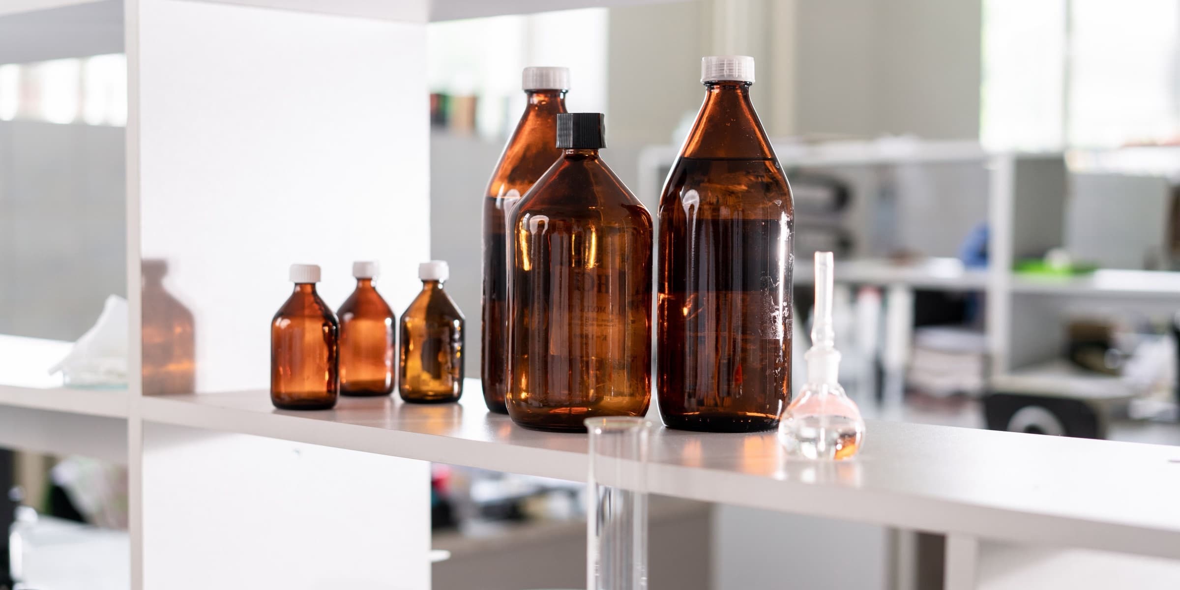 Brown glass bottles on a laboratory shelf